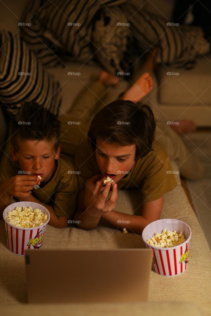 kids watching a movie, chewing popcorn and horror fear, horror movies