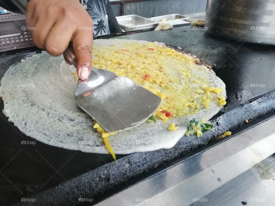 A dosa is a cooked flat thin layered rice batter, originating from the South India, made from a fermented batter. It is somewhat similar. Its main ingredients are rice and black gram ground together in a fine, smooth batter with a dash of salt.