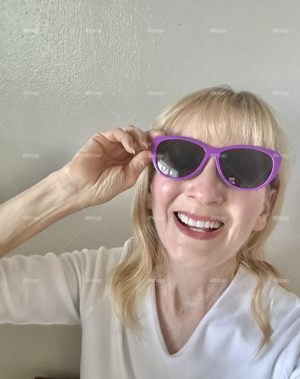 Woman laughing wearing purple sunglasses 