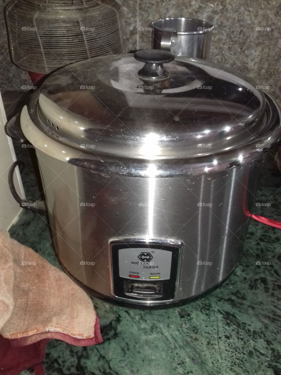 electric rice cooker made of stainless steel where reflection due to light and tiny scintillation are seen at certain places