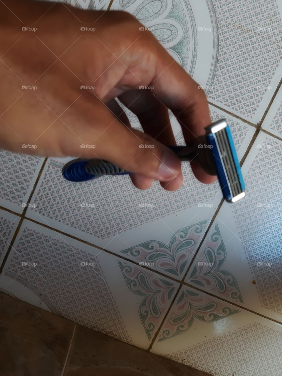 A blue shaver in a left hand.