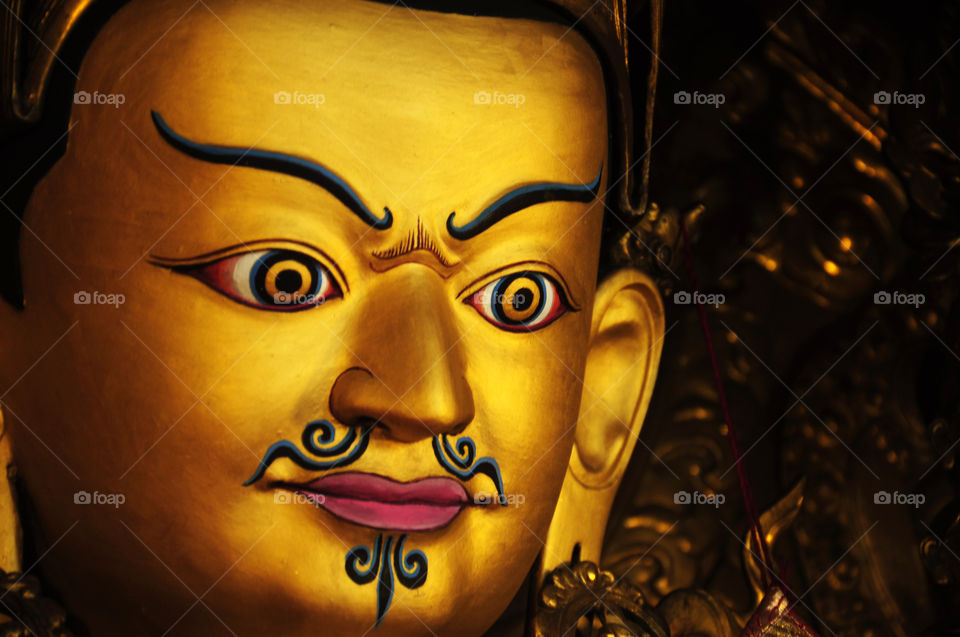 yellow gold statue of padmasabhava