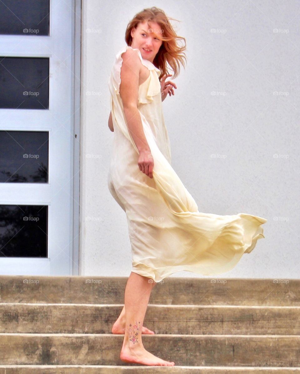 Dancing and fluttering in the breeze in front of an urban geometric architectural building.