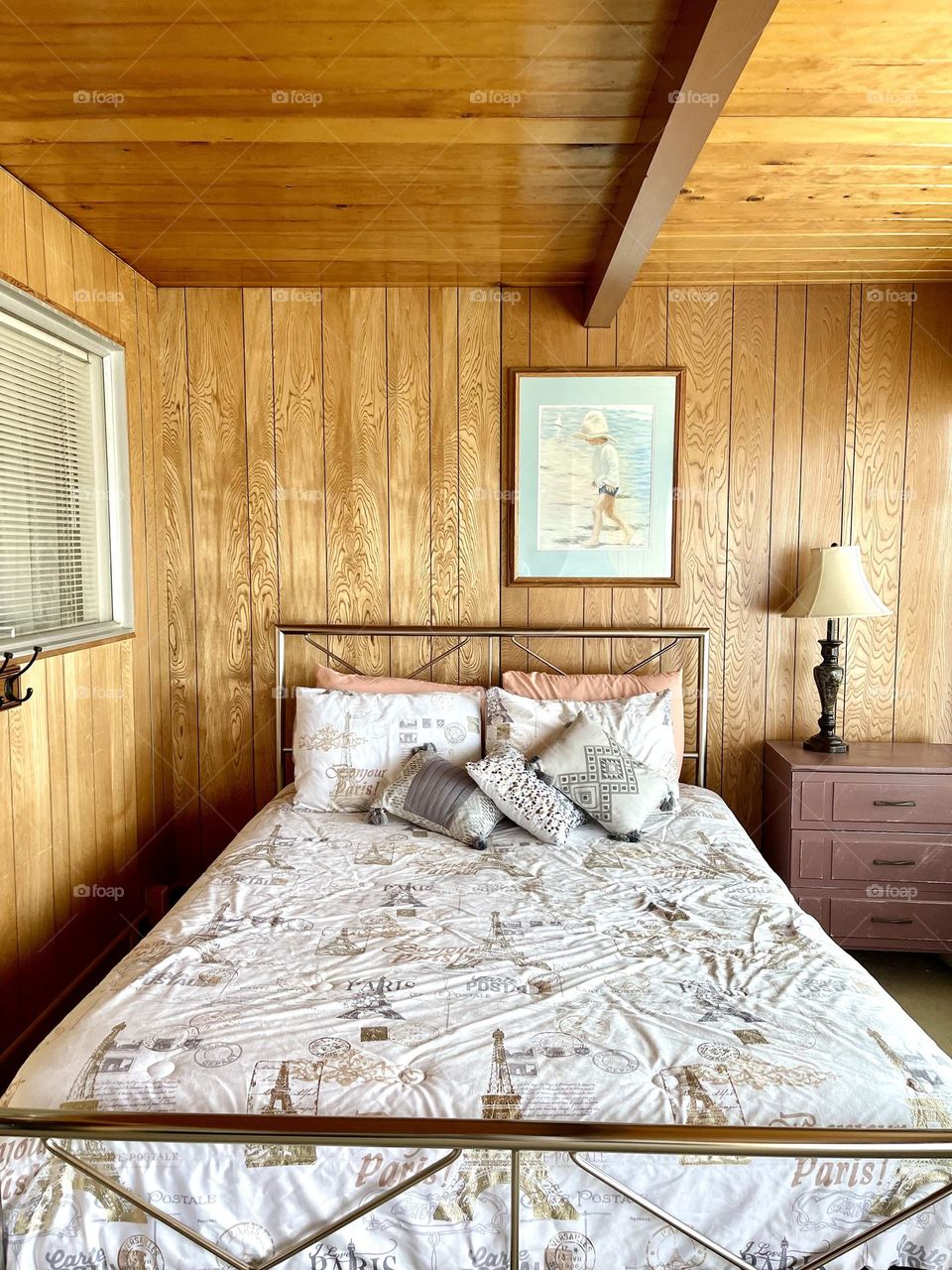 Cozy bed in summer house with wooden walls 