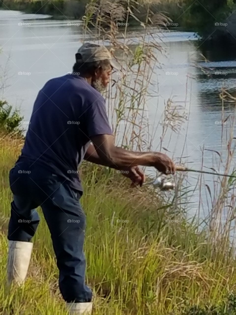 Mature fisherman fishing in river