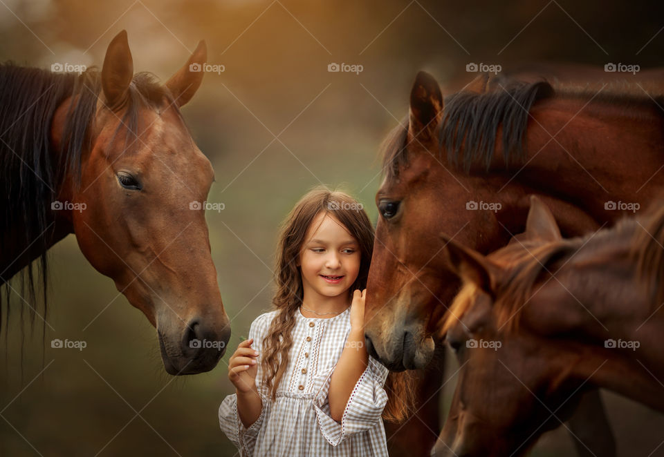 Little girl with herd of horses