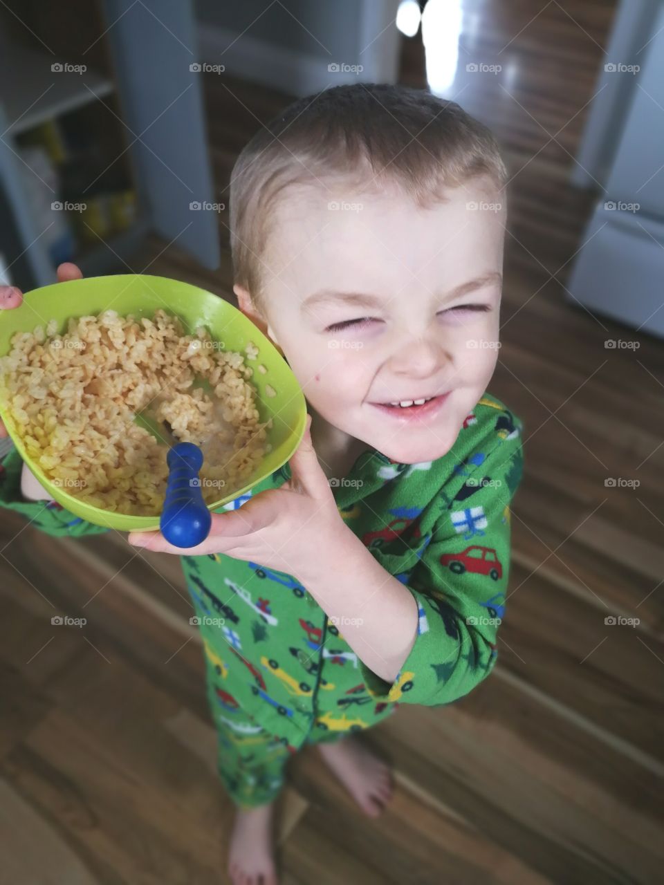 a small boy smiling while listening to his cereal pop