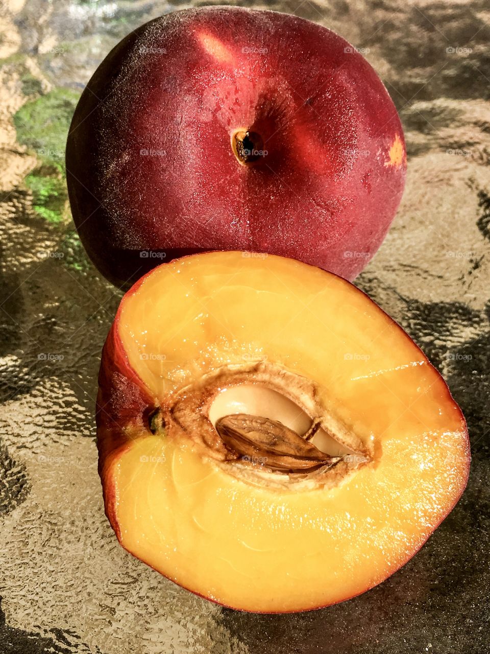 Orange fleshed nectarine whole and halved still life closeup