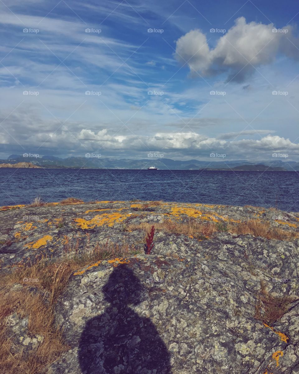 Shadow on the island looking at the ferry on the horizon 