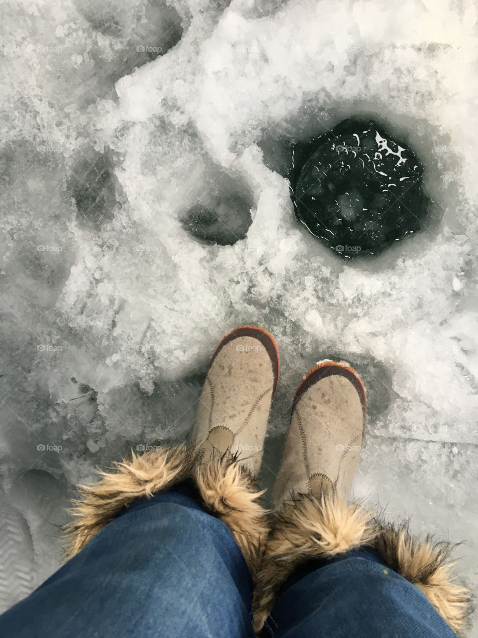 A person standing near the ice hole