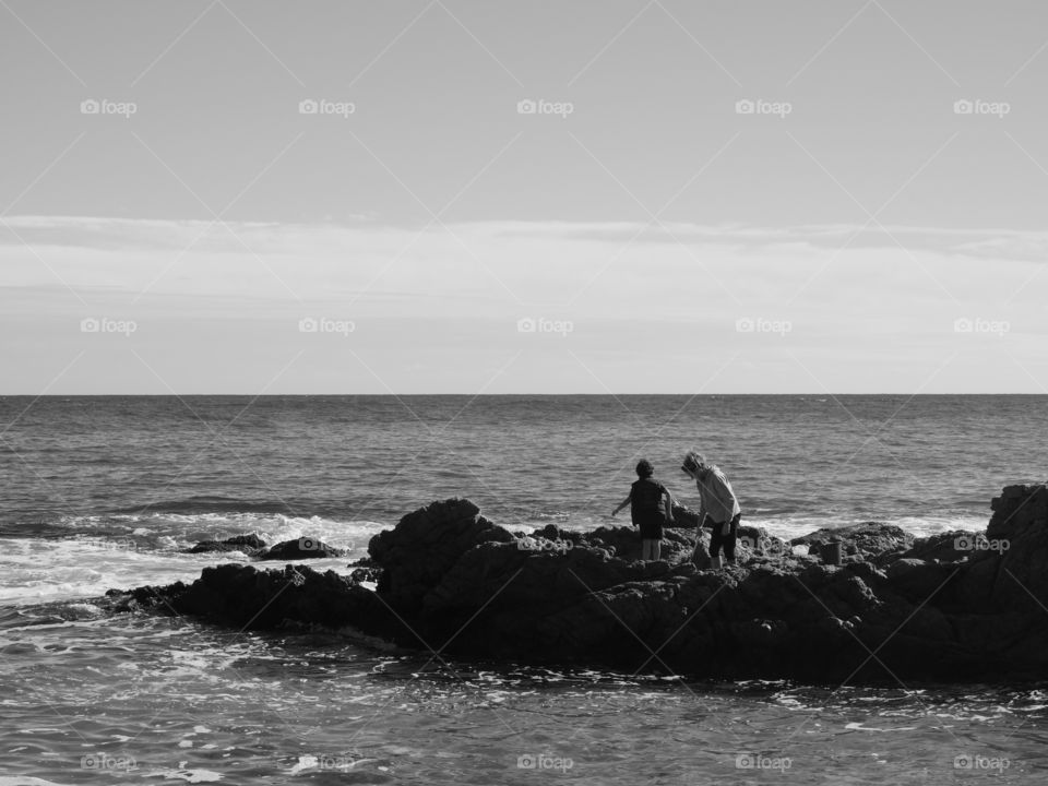 dos personas rocas mar