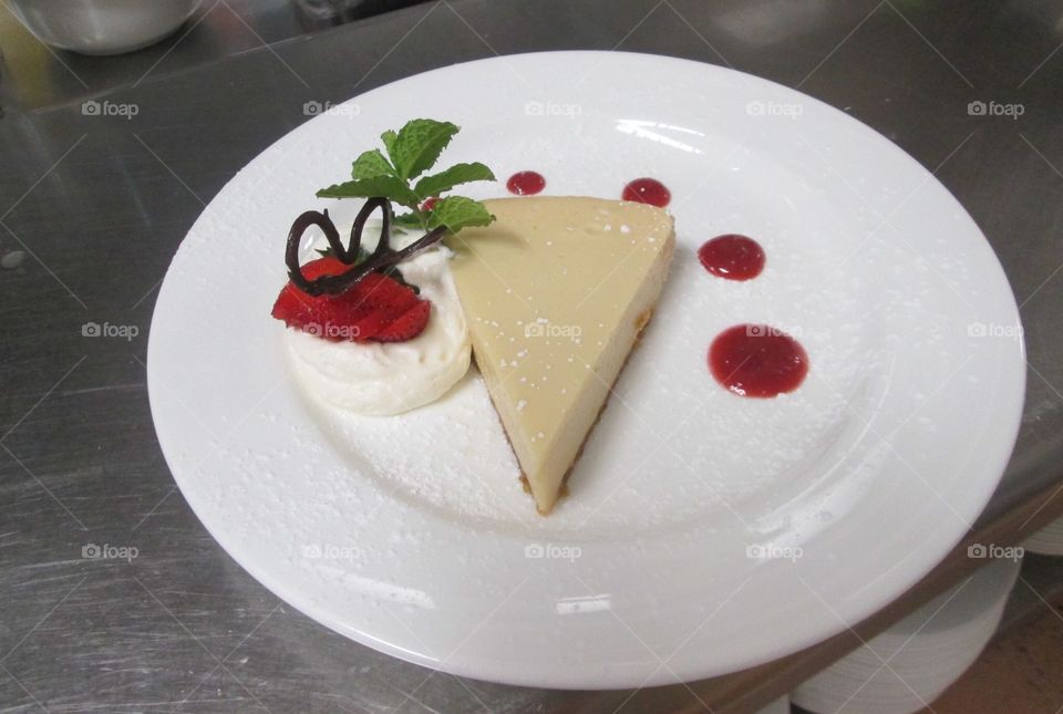 Key lime pie with berry sauce and chocolate butterfly