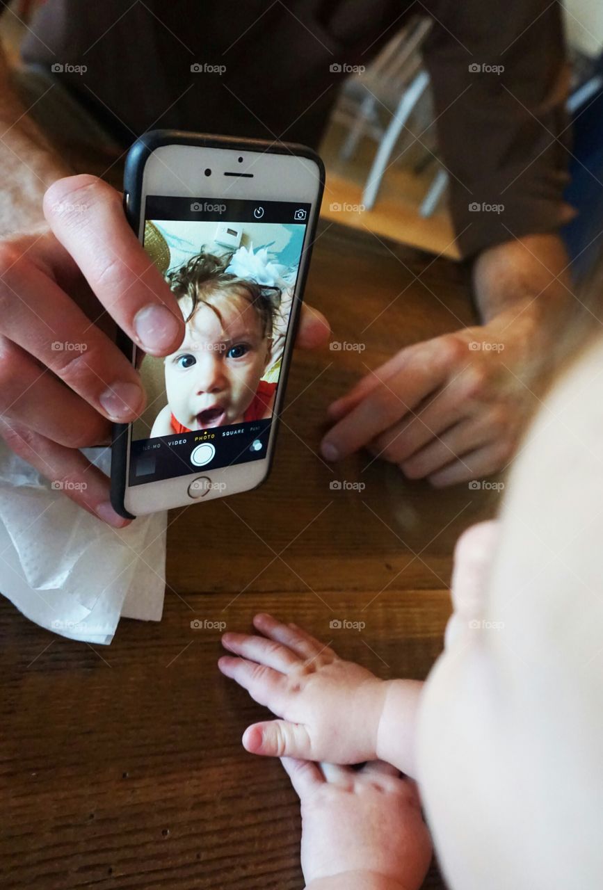 Man showing his baby photo on cellphone