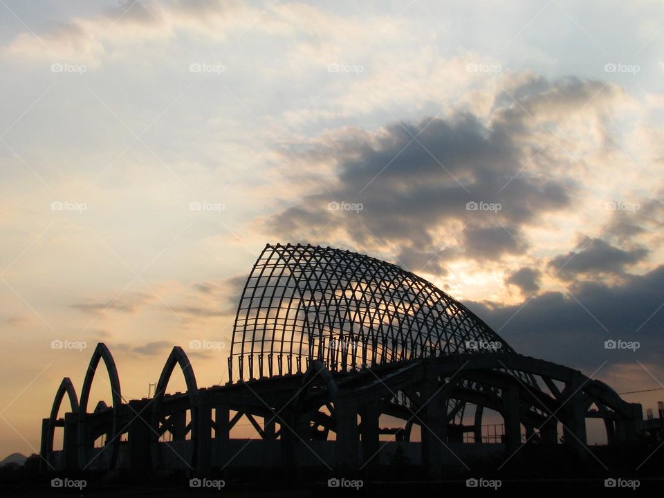 Portrait of a large unfinished building structure with a beautiful twilight sky in the background