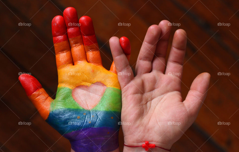 Together. Two hands touching, rainbow colors of pride, a heart and a cross symbol