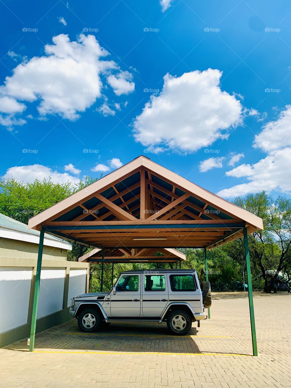 A black striped silver Mercedes Benz G-wagon (G-class) parked in shaded parking lot. 