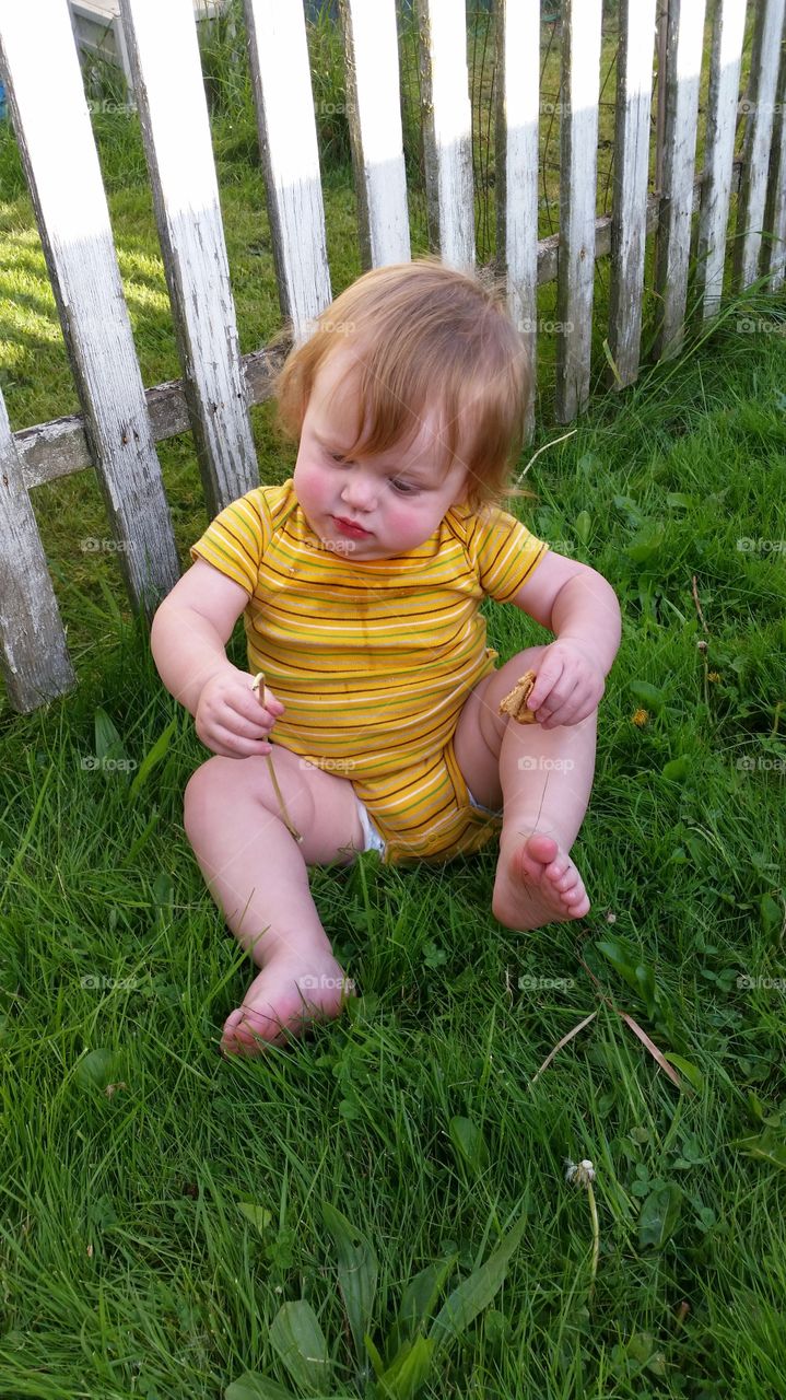 my beautiful boy trey playing in the vivid green grass and his popping yellow onesie, red hair all goes so well