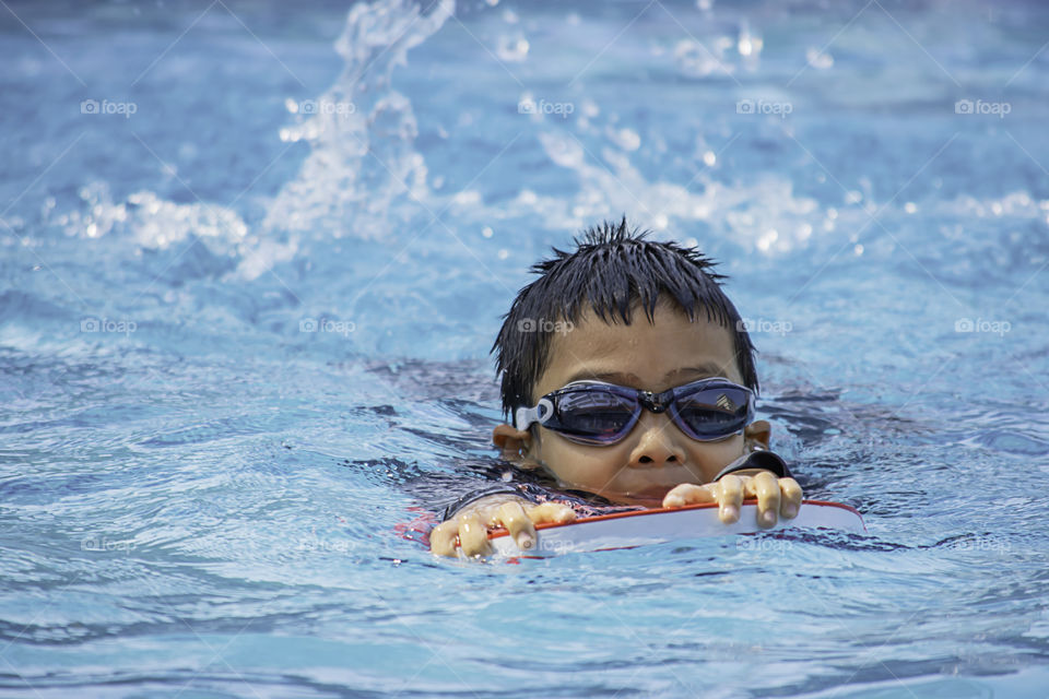 Asean boys are swimming in the pool.