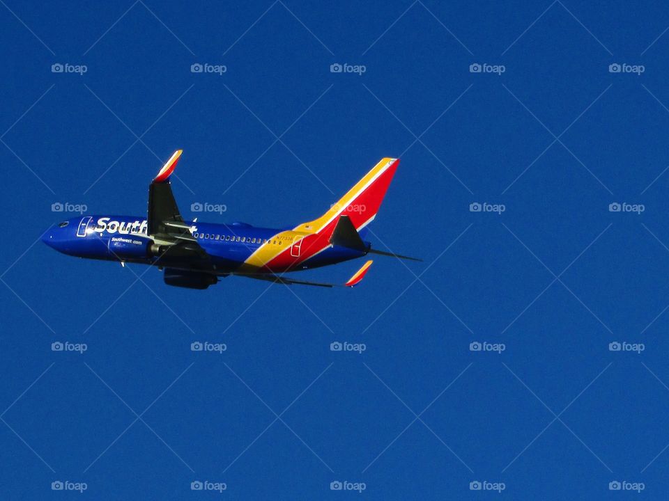airplane taking off from a metropolitan airport flying high in the blue skies