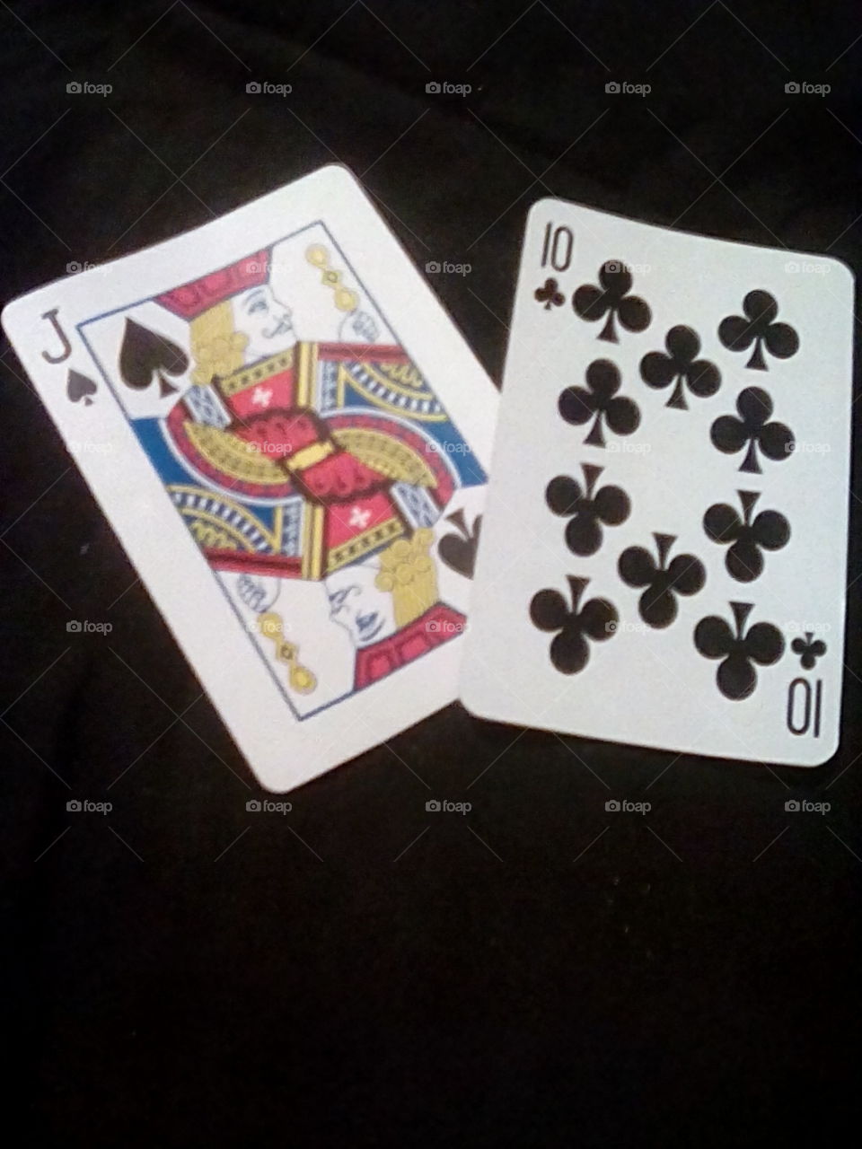 Two playing cards placed over a dark surface
