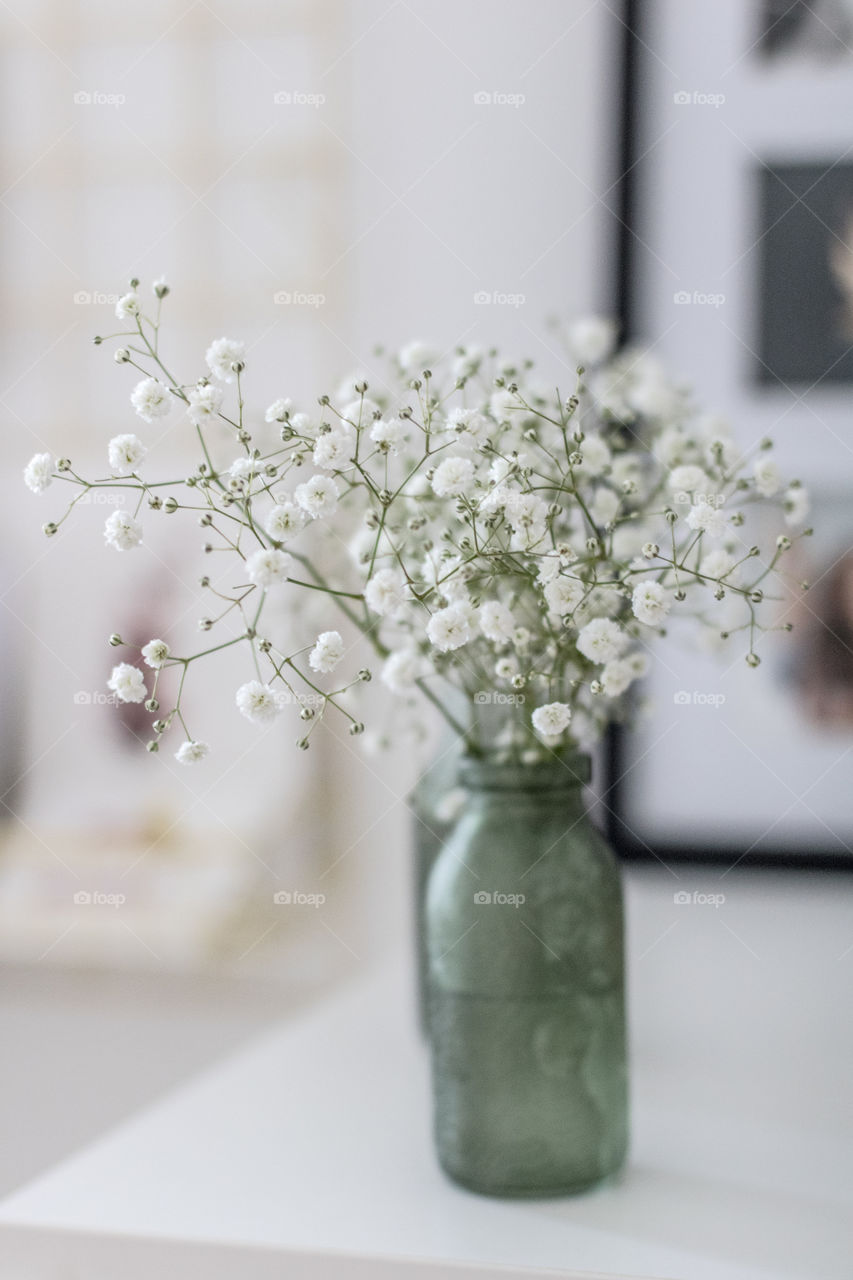 Small white flowers in a green vase