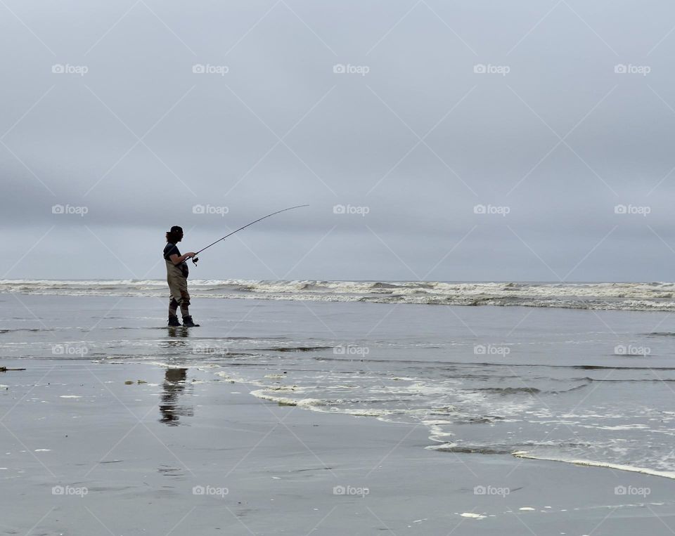 Fishing man on the bank of the ocean 