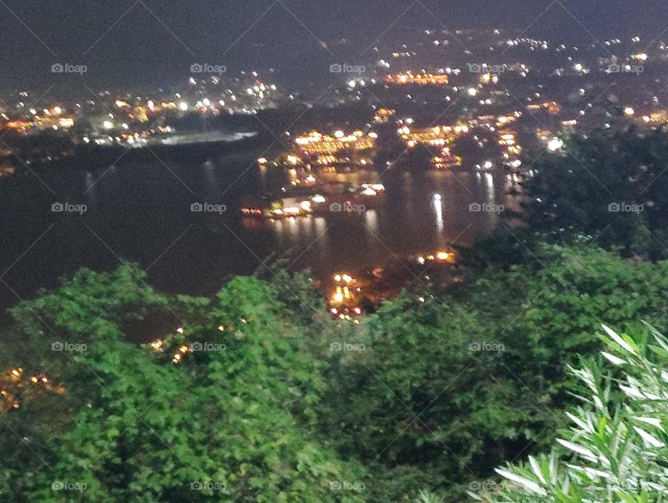 night scene from very high distance in a roap way, small house and shops with yellow light green plant shurb, reflection of light very beautiful