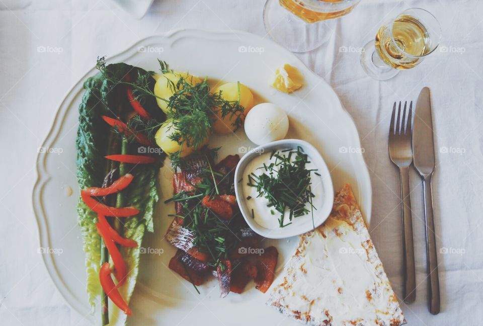 Top-shot of a dish with potatoes, herring, vegetables on a plate 