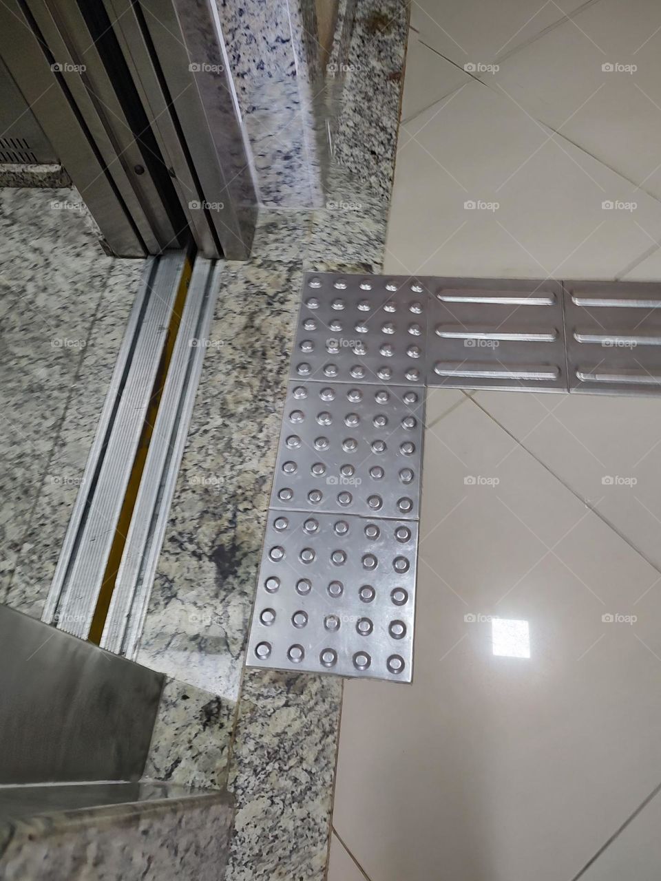 three squares of tactile security floor form a rectangle facing the elevator door