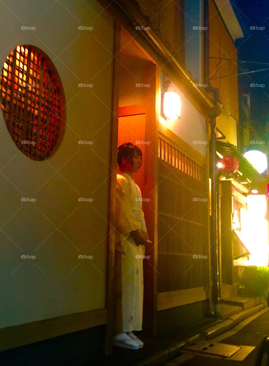 Kyoto Japan doorway with Japanese girl watching those walking past.