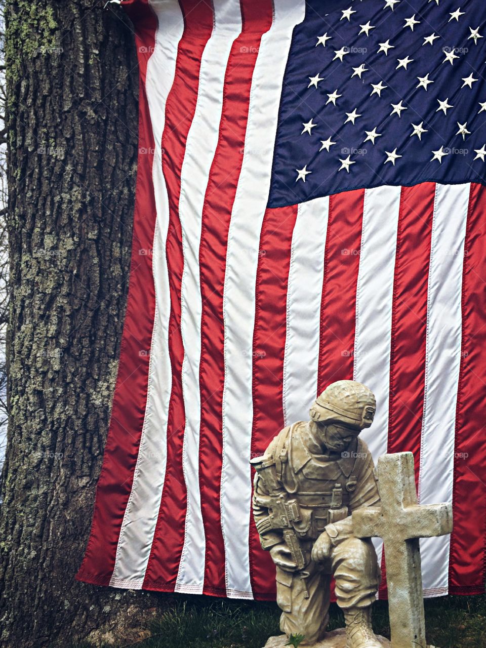 Close up of Soldier Memorial Statue with American Flag in background