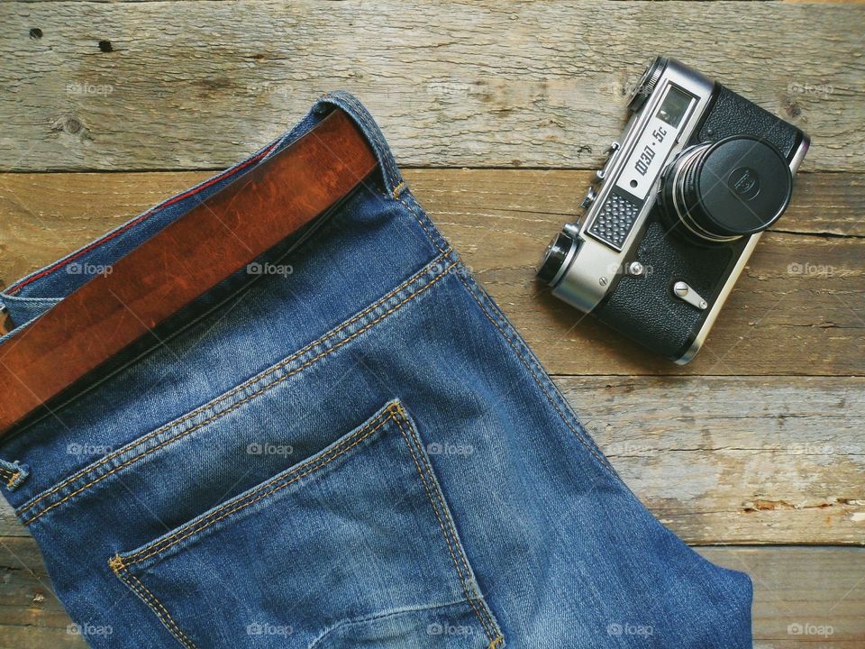 Blue jeans, a leather belt and and an old camera