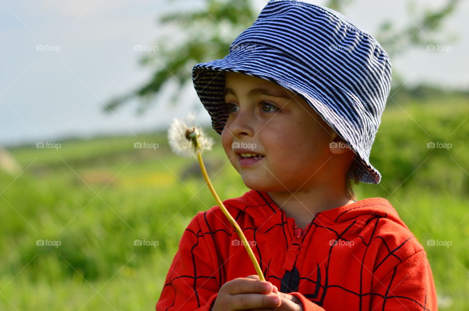 Boy holding dandelion flower