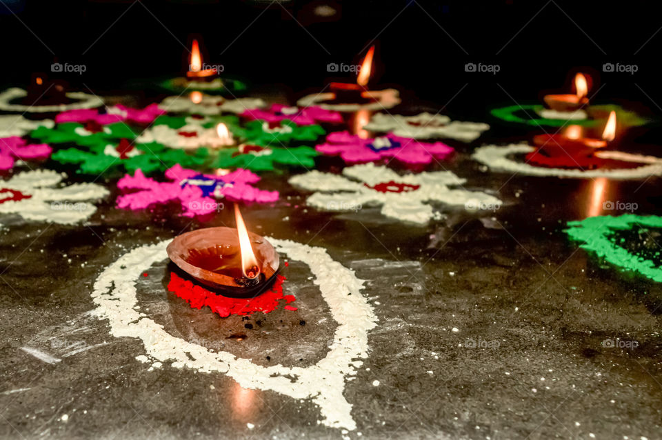 Diya Oil lamp in Rangoli decoration in Diwali festival. Concept of removing darkness.