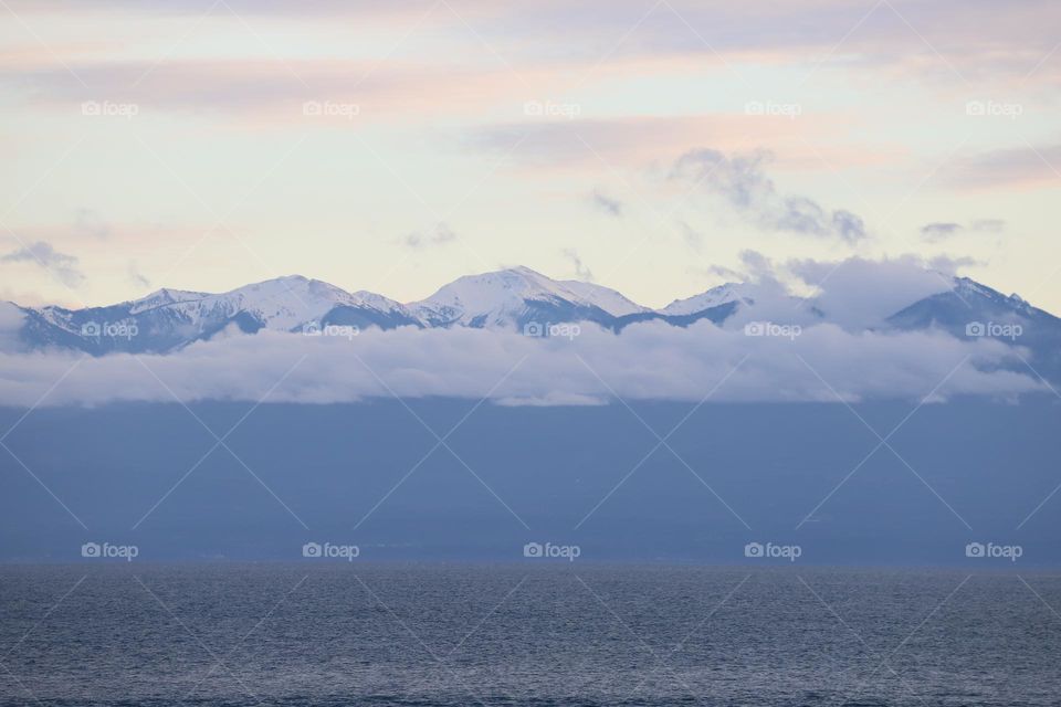 Snow caped mountain above the ocean 