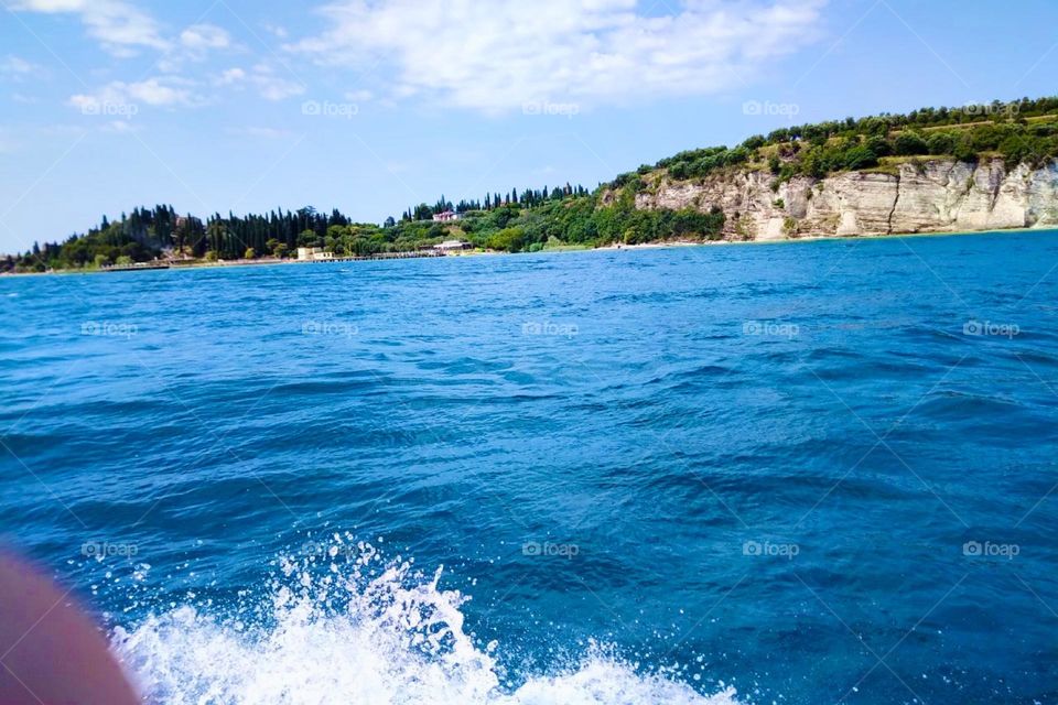 Careful, there’s water splashing directly at us from the clear blue „Lago di Garda“, the „Lake Garda“ in northern Italy near the „Alps“. Oh how beautiful  our Lord God’s creation can really be. Here life is to be enjoyed. 2023. Hypnotic Productions