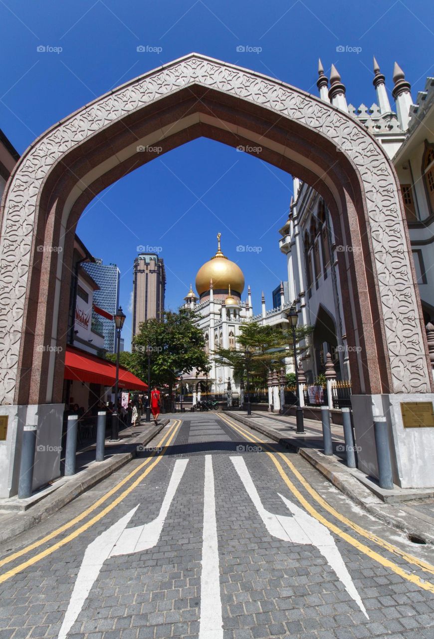 Masjid Sultan mosque in Singapore seen through the portal down the road with arrows pointing into opposite directions.