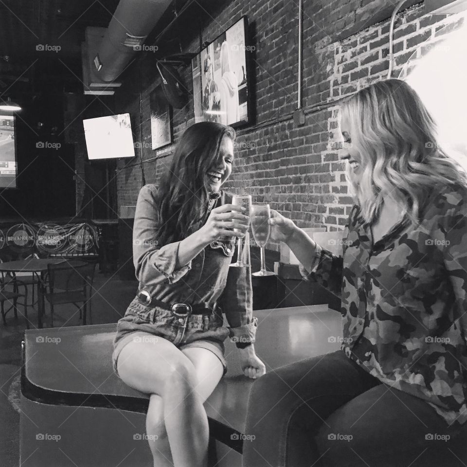 Happy young women in restaurant with wine glass