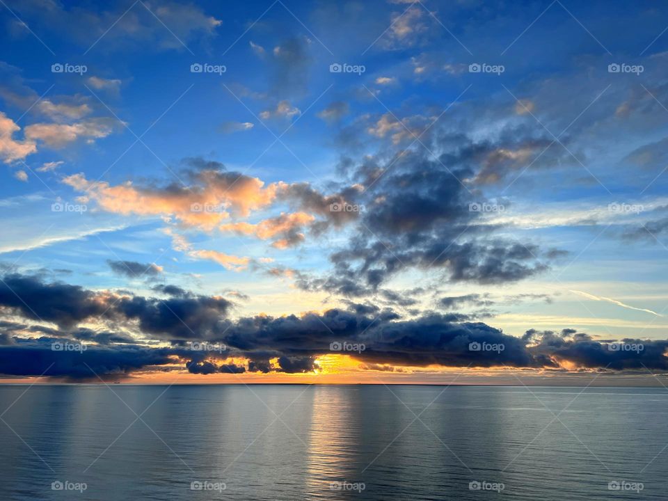 Amazing sunset view over the Baltic Sea archipelago with clouds reflection in the still mirror smooth water surface