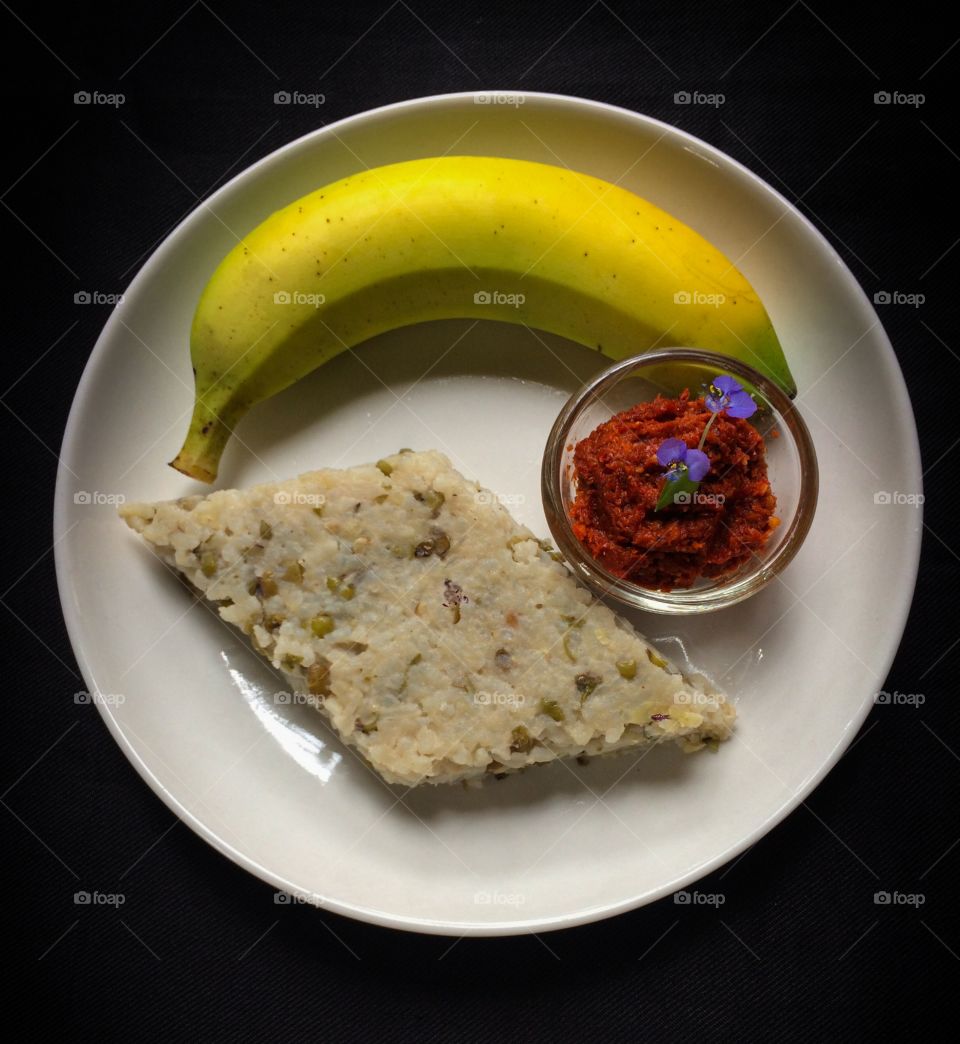 Nutritious and balanced Sri Lankan breakfast food plate over black surface .