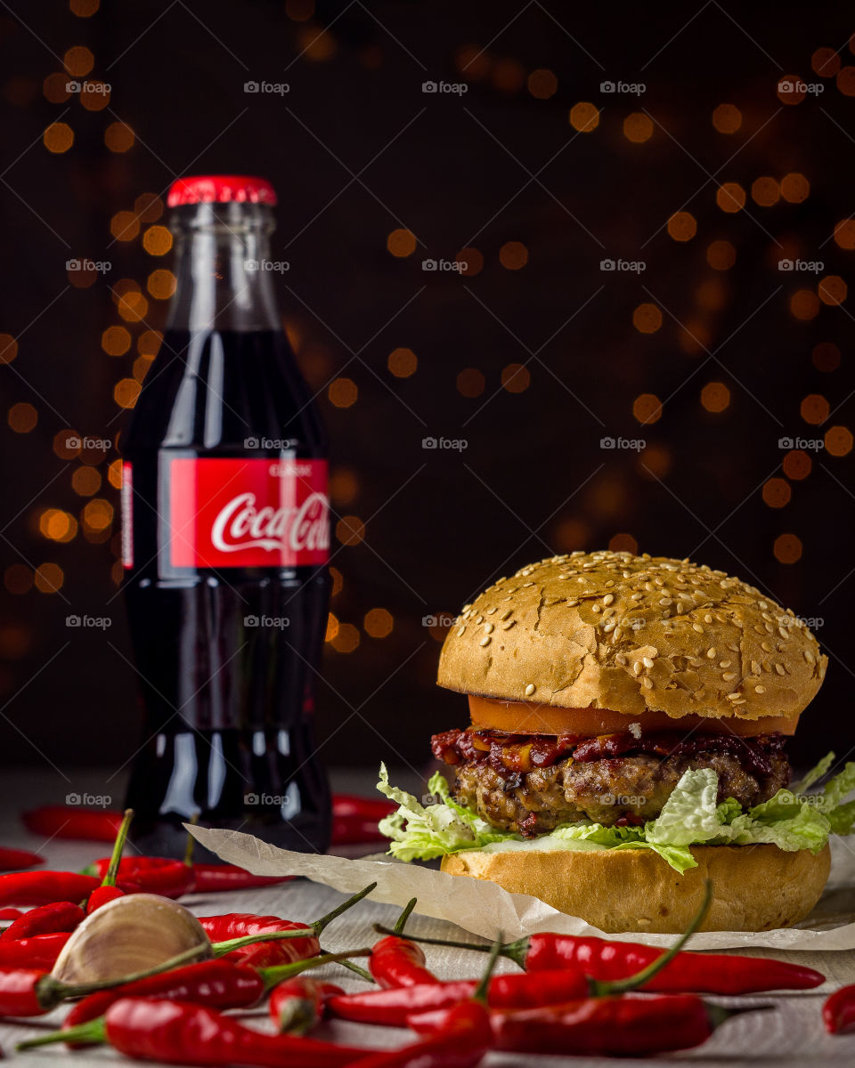 Hot spicy beef burger with chilli pepper is good with Coca-Cola.
