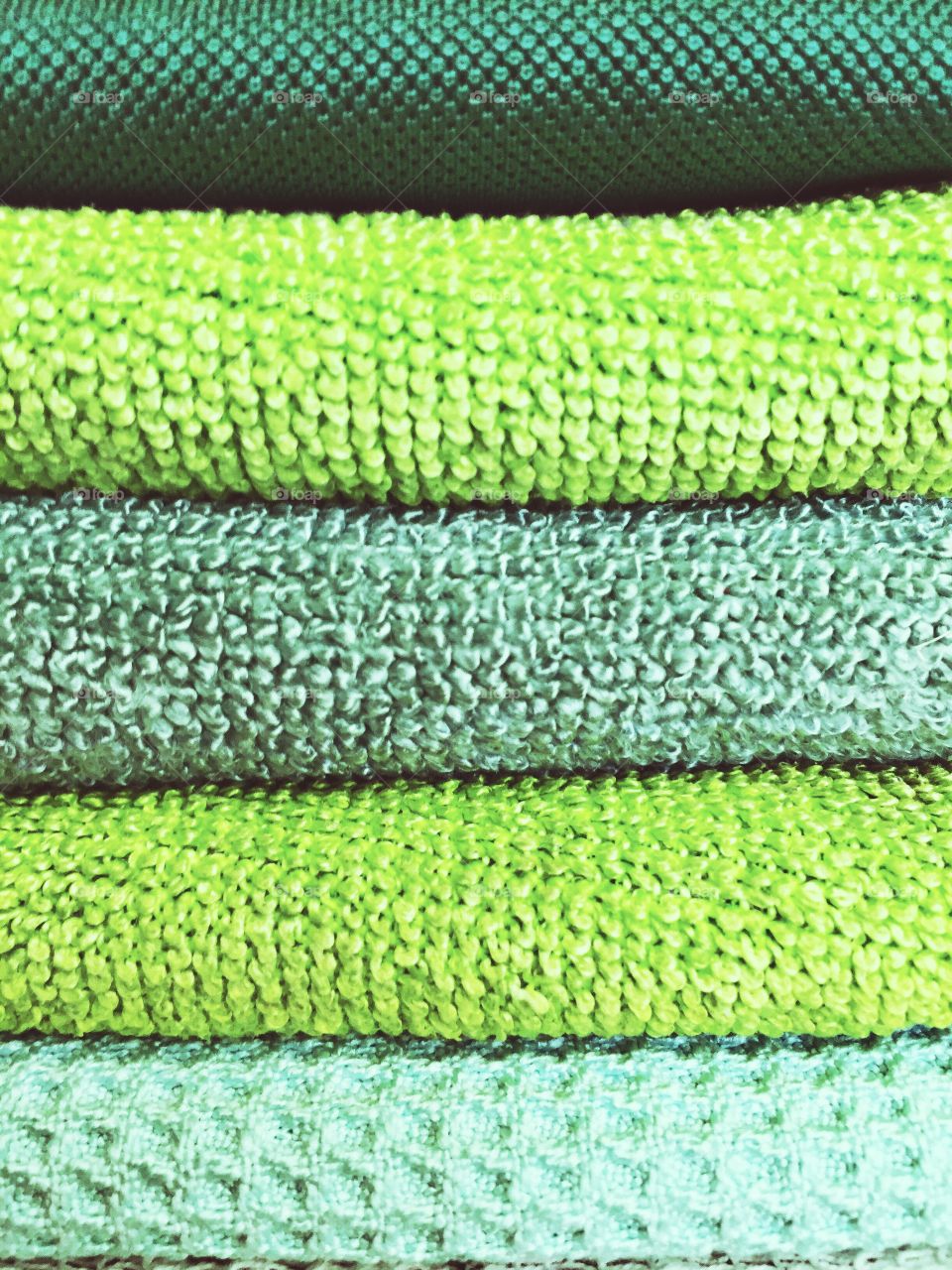 Green Color Story - Stack of folded microfiber cloths of various textures and shades of green 