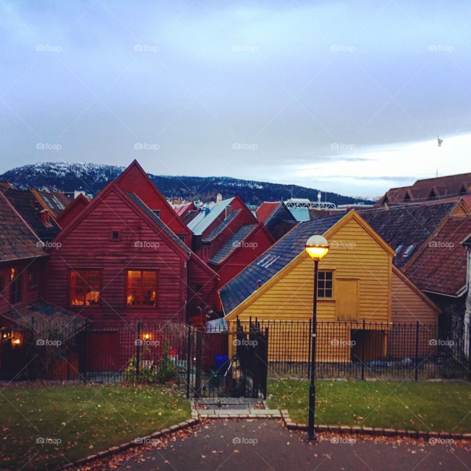 Snow capped hills around wooden buildings in bergen, Norway 
