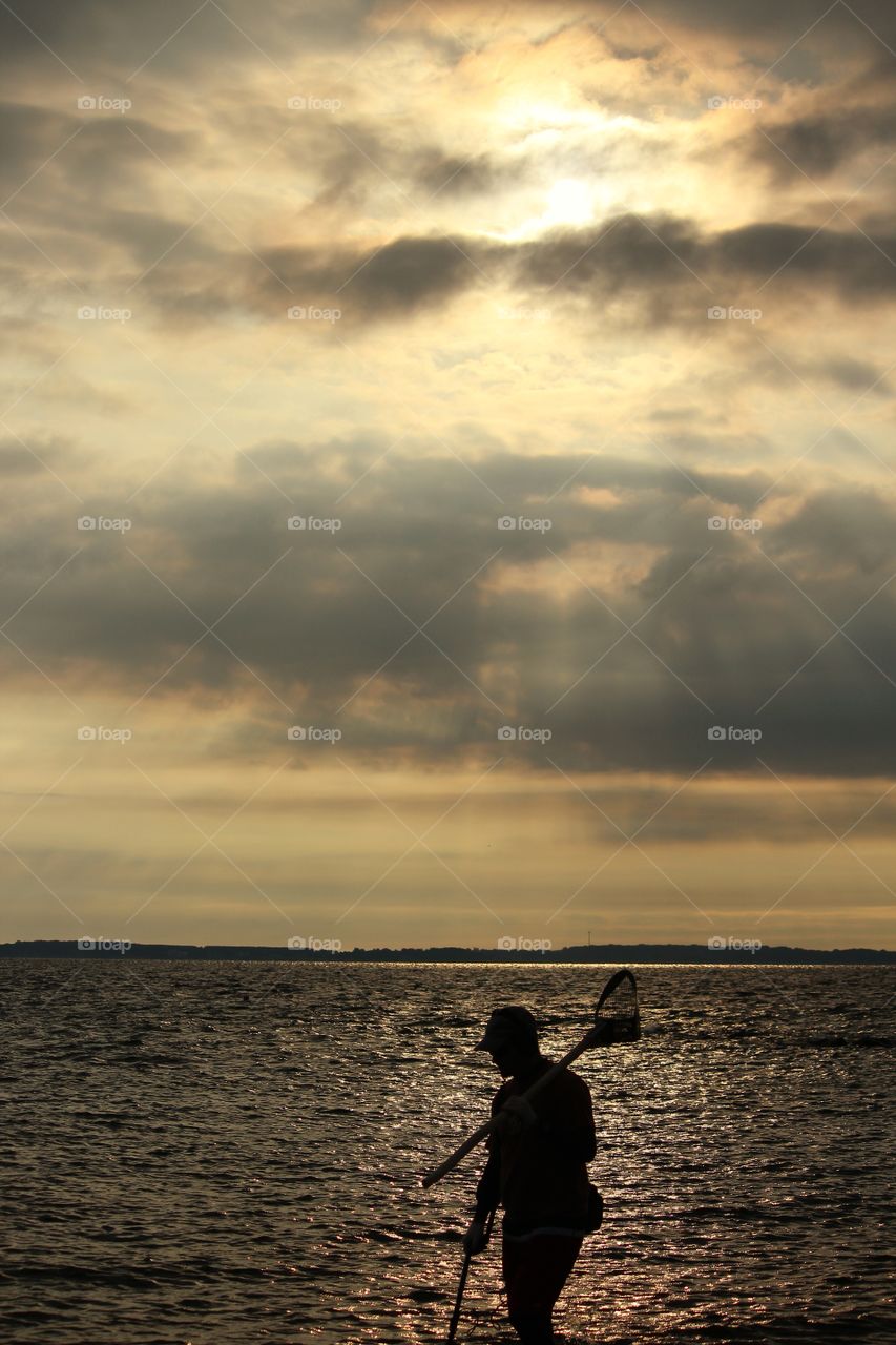 Silhouetted Man At The Beach Toting Metal Metal Detector