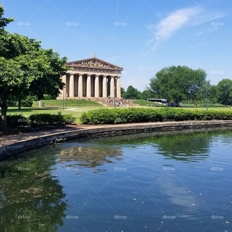 View of the parthenon across a still pond in Centennial Park in Nashville
