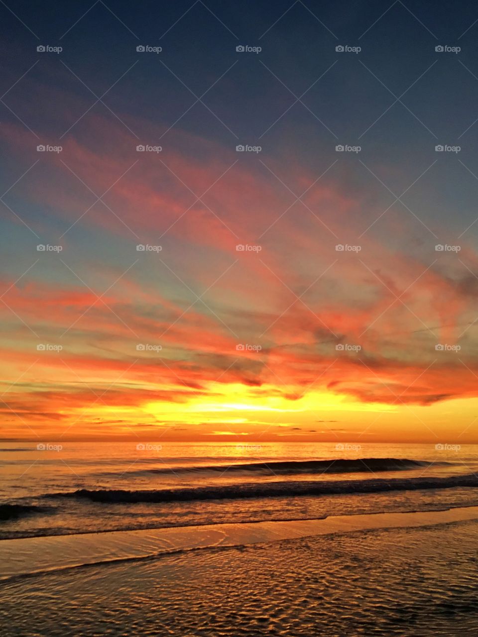 
Mesmerizing sunset - Bright streaks of red, pink, and orange slowly overcame the dark blue and purple of the twilight sky. The sky resembled a prism; all the colors blended perfectly into each other 