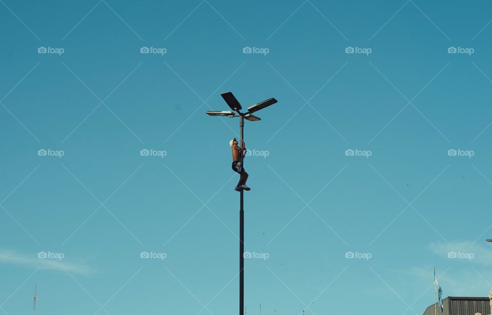 Man climbing a light pole in Argentina
