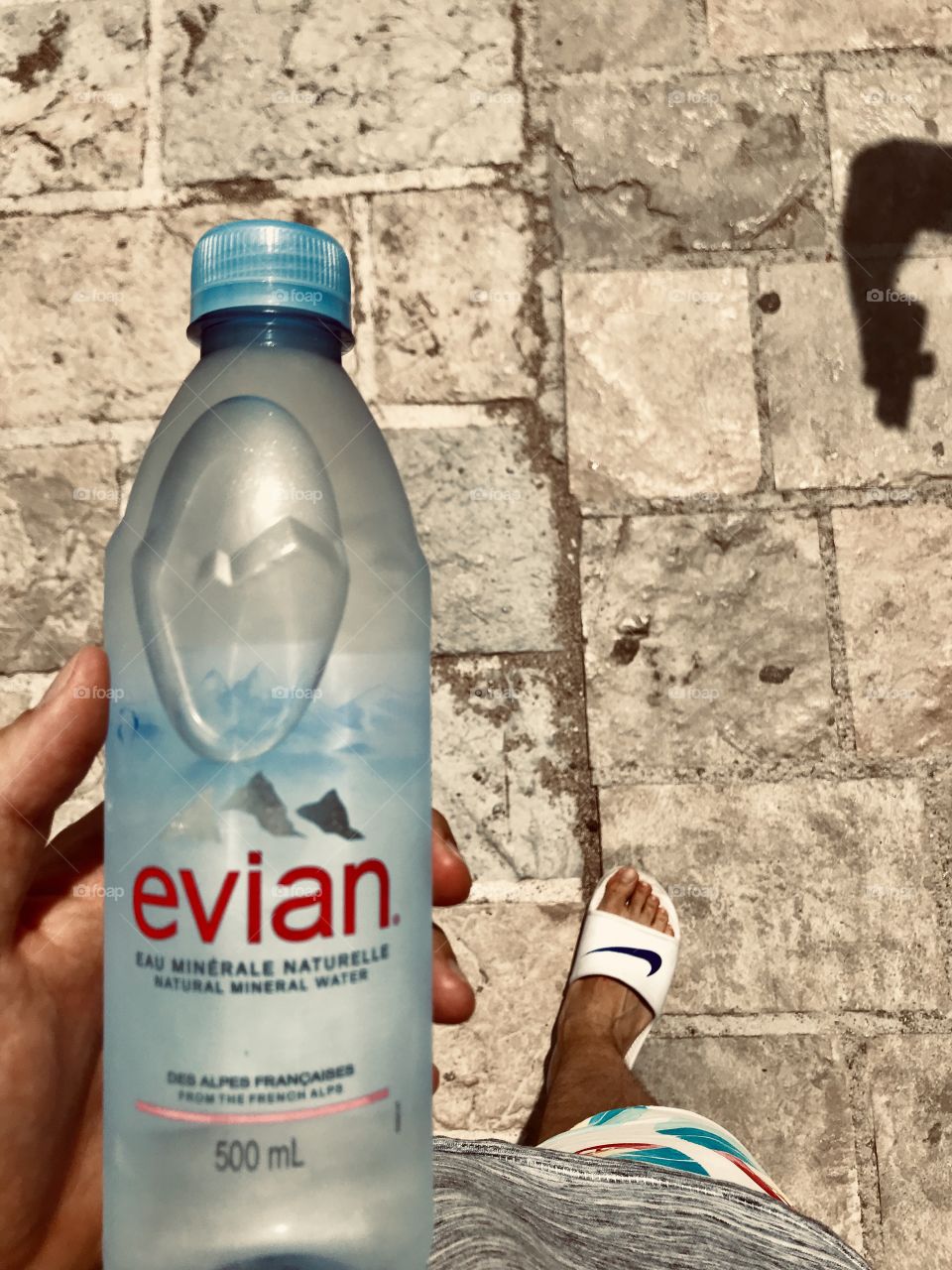 Fresh Evian water in hand,summer cooling off from hot air.