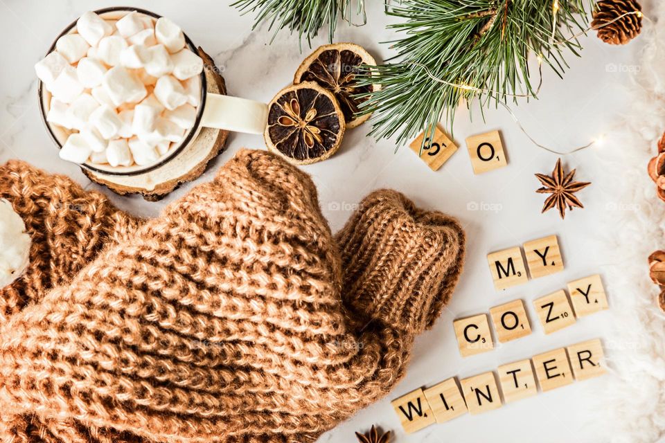 Cozy knitted sweater and cup of hot cocoa with marshmallow 