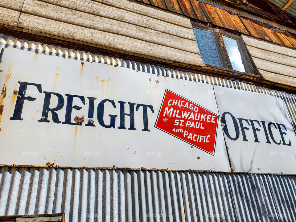 An old sign on an old building indicates that it is a freight office